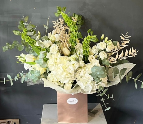 all white and green flowers vase to include white hydrangeas, roses, bell of irland, dry elements arranged in natural way giving impression of wild look. Made by Blooms and Candy London florist with guaranteed London UK delivery