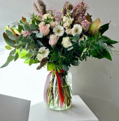 Stunning light vase with mixture of foliages and types of Eucalypthus to include pastel roses and daisies complementary with natural dry elements.  Glass vase included.