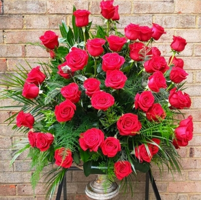 luxury 75 biggest heads red roses arrangement in elegant vase for a display. Made by Blooms and Candy London, UK florist with guaranteed delivery