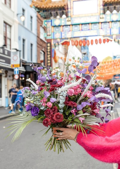 Fun and cheerful pink and purple bouquet dressed with wild foliages. Made by Blooms and Candy London florist with guaranteed London, UK flower delivery