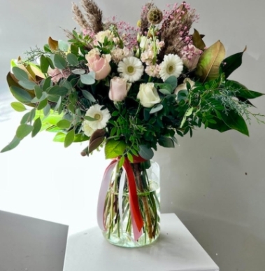 Stunning light vase with mixture of foliages and types of Eucalypthus to include pastel roses and daisies complementary with natural dry elements.  Glass vase included.